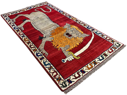 Rug with a red background, white border, and animal motif in gray and orange