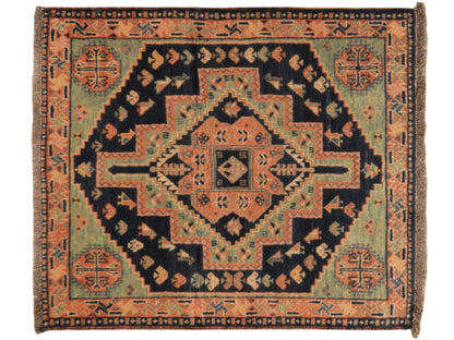Teppich mit symmetrischem Medaillon und Rankenornamenten in Orange, Blau und Schwarz