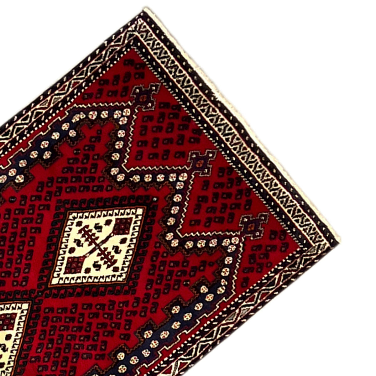 Corner view: red rug with a geometric pattern in dark blue and cream