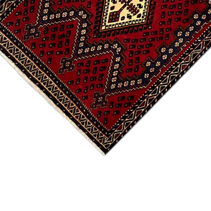 Red runner rug with diamond ornaments and decorative border in dark blue