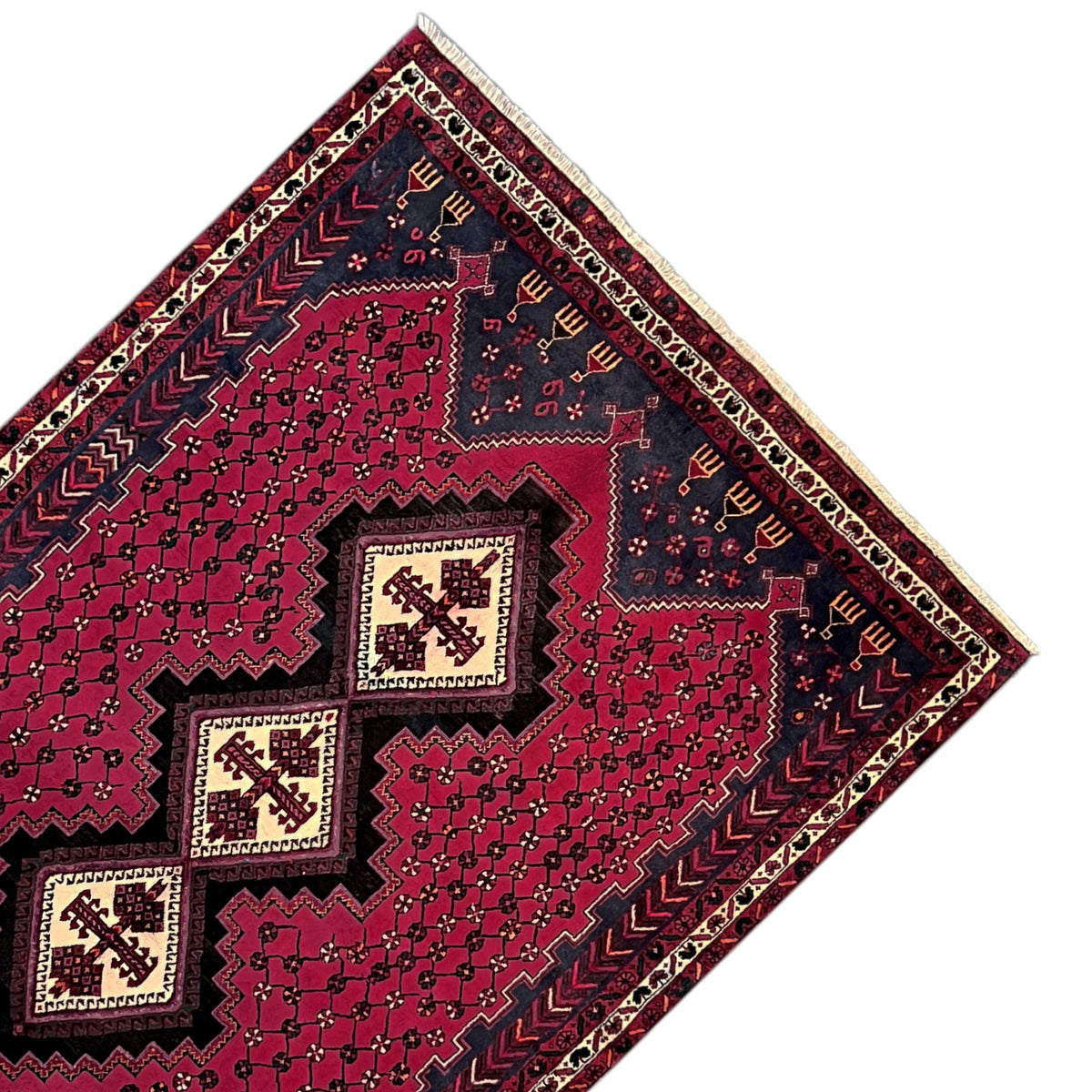 Rug shown at an angle: red pattern with four small medallions and a dark blue border