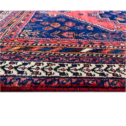 Close-up of a rug edge with a multicolored border pattern and fringes