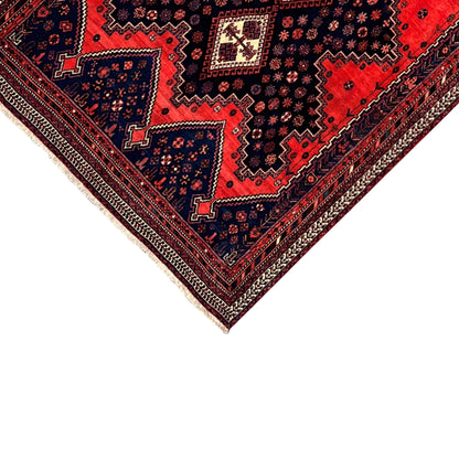 Close-up of an Oriental rug: red and blue ornamental pattern, border along the edge