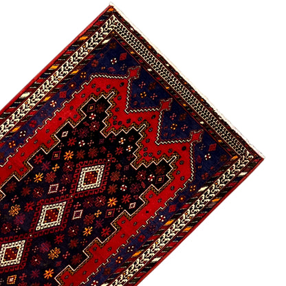 Rug runner corner with a red inner area, blue accents, and a beige border pattern