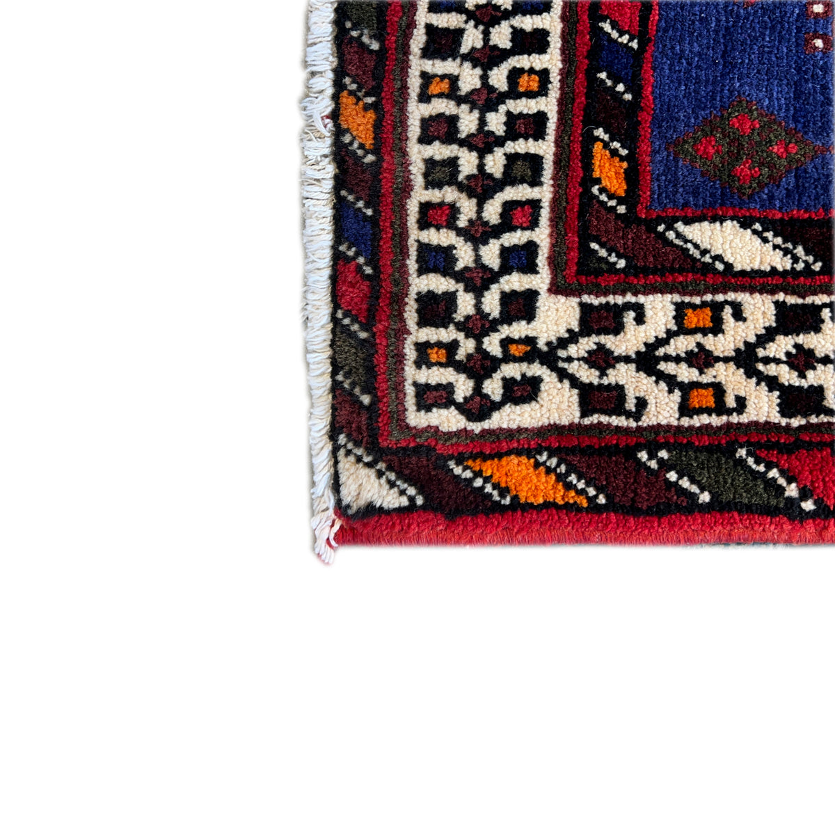 Runner rug edge with a multicolored ornamental pattern and reddish-brown pile