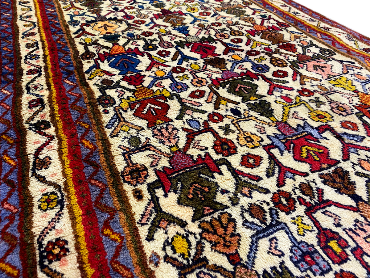 Close-up of the carpet pattern: colorful ornaments on a light background with a red border line