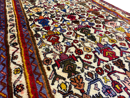 Close-up of the carpet pattern: colorful ornaments on a light background with a red border line