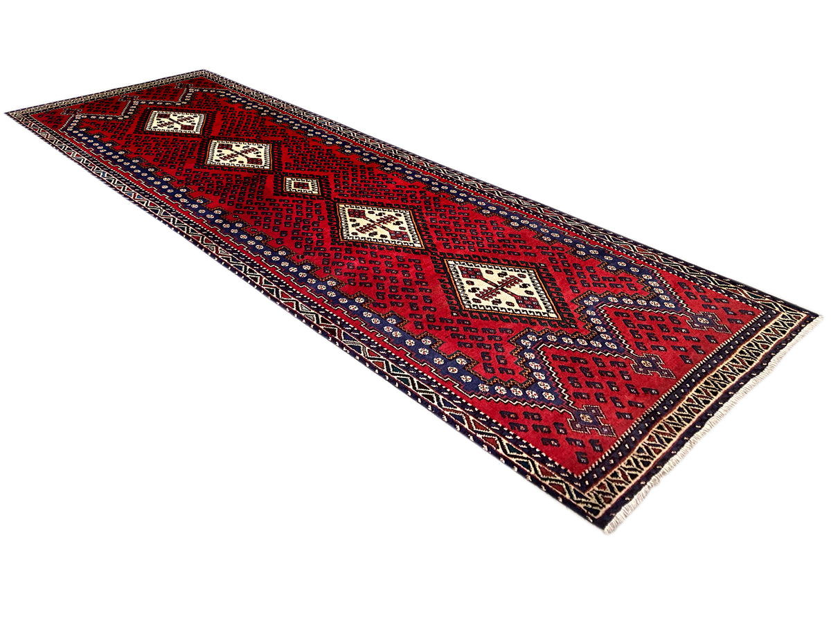 Red runner rug with geometric pattern and fringes, 280×89 cm