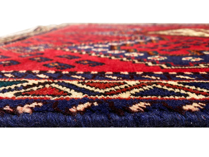 Red runner rug in detail with a multicolored pattern and woven edge