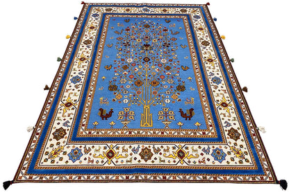Blue oriental rug, laid flat, with a colorful border and corner fringes
