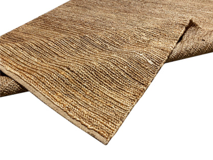 Jute-Teppich in Naturbraun mit sichtbarer Kettel-/Saumkante an der Ecke.