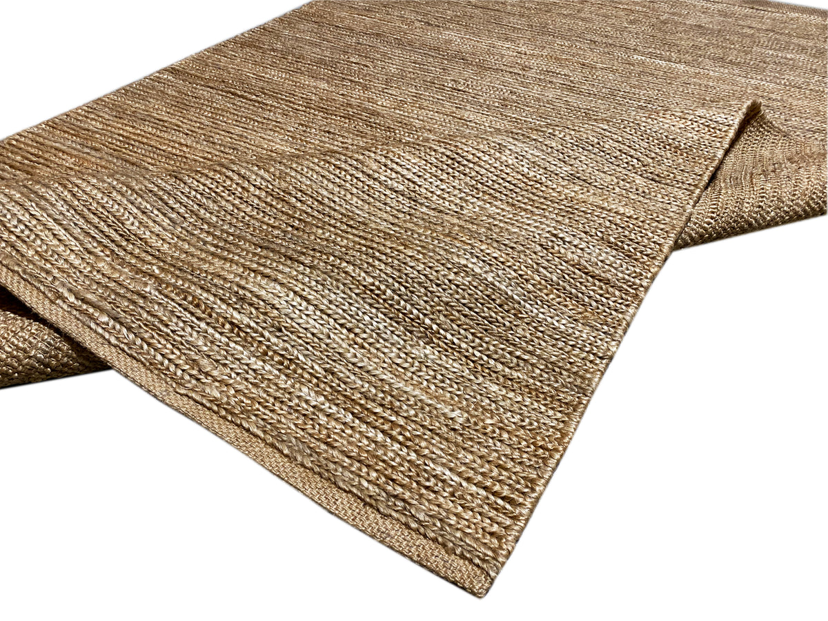 Rug with a neatly bound edge, mottled in shades of sand beige to brown