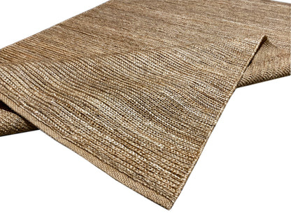 Rug with a neatly bound edge, mottled in shades of sand beige to brown
