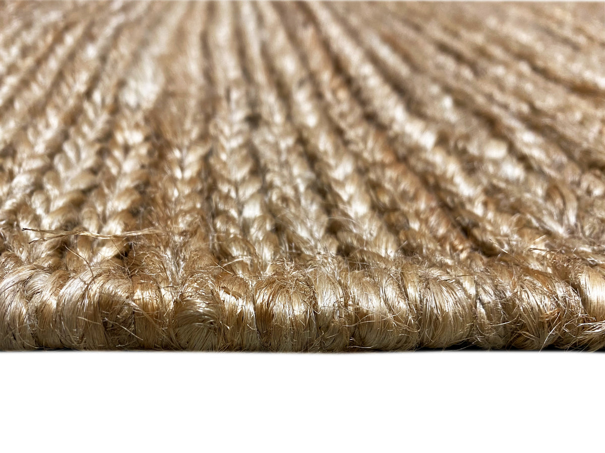 Carpet surface detail: short beige pile fibers with an even weave