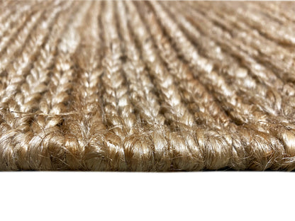 Carpet surface detail: short beige pile fibers with an even weave