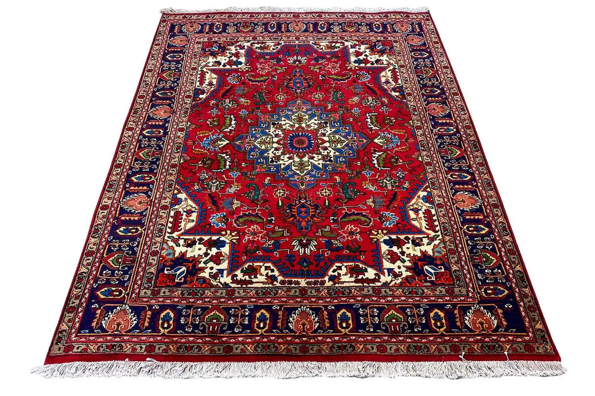 Red embossed rug with a central medallion, multicolored border, and fringes
