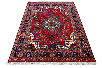 Red embossed rug with a central medallion, multicolored border, and fringes