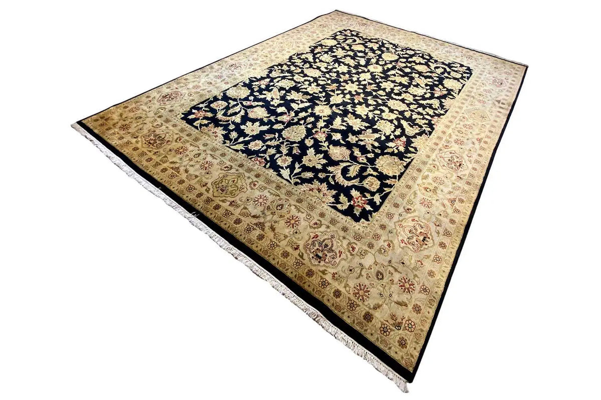 Rug viewed at an angle, dark blue with gold and cream-colored floral ornaments