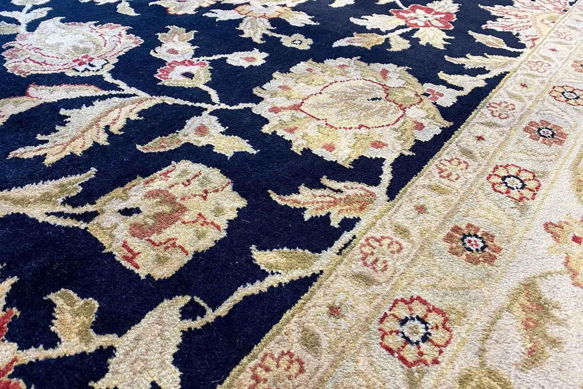 Close-up of the carpet: dark blue field with cream-colored and red pile details