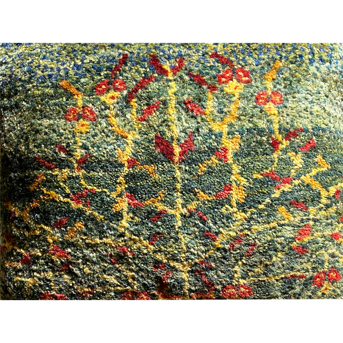 Close-up of a wool cushion: textured wool fabric with a colorful floral embroidery pattern