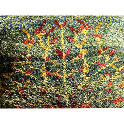 Close-up of a wool cushion: textured wool fabric with a colorful floral embroidery pattern