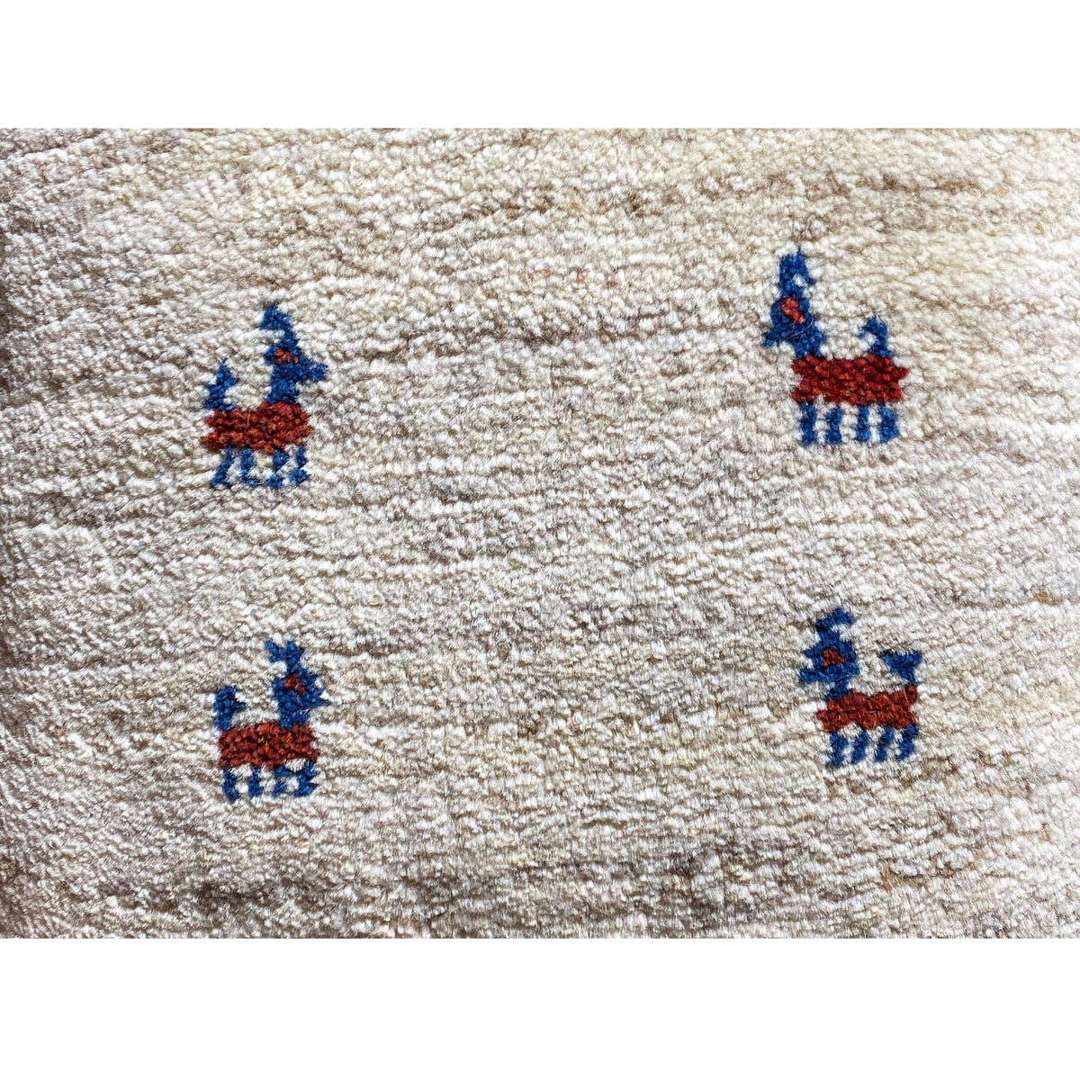 Wool cushion 40x40 cm: close-up, beige wool fabric with a blue-and-red embroidered figure