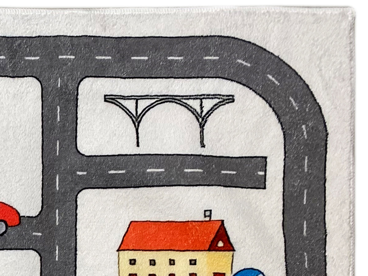 Kinderteppich-Detail: Straßenbogen mit Haus- und Brückenmotiv auf beigem Grund