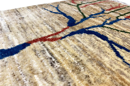 Gabbeh rug detail: beige background with a blue tree branch and fine lines of color