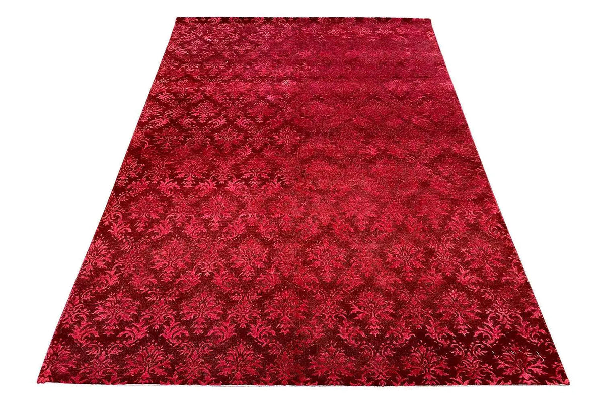 Red carpet with an all-over Baroque pattern and a dense, textured surface