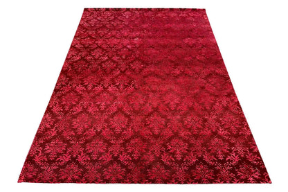 Red carpet with an all-over Baroque pattern and a dense, textured surface
