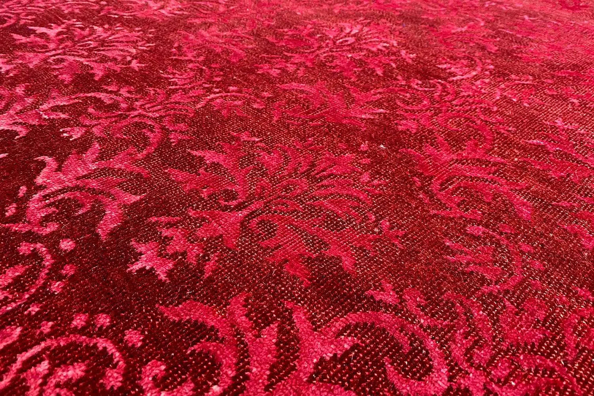 Close-up: red carpet with an ornamental pattern and dense, fine texture