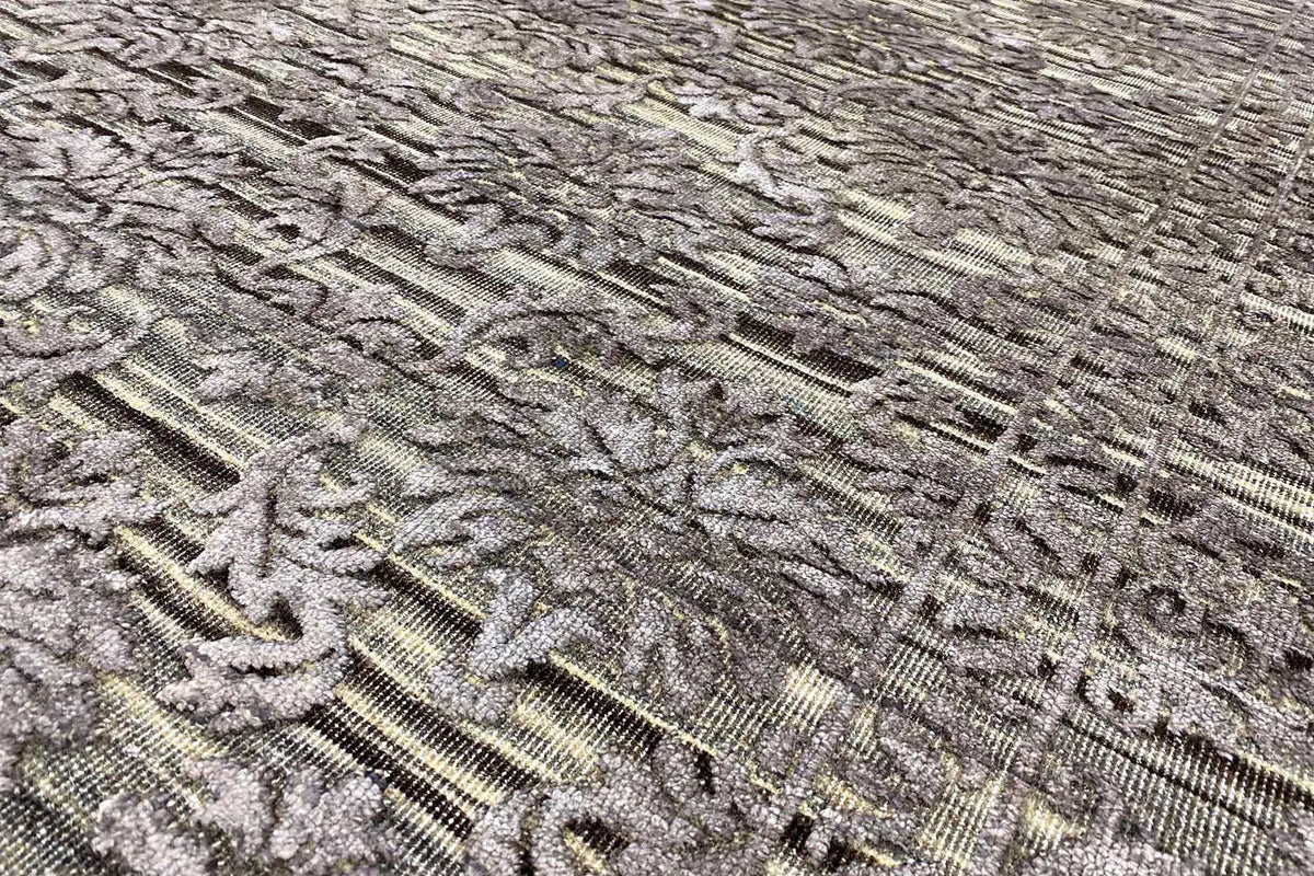 Carpet surface close-up: relief-like ornament in gray, finely textured lines