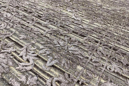 Carpet surface close-up: relief-like ornament in gray, finely textured lines
