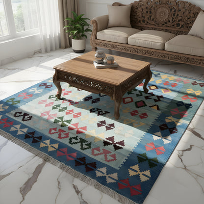 Blue kilim rug with a multicolored pattern, lying by the living room table, fringes