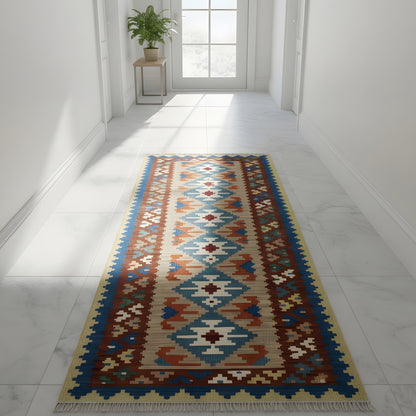 Kilim rug in the hallway: geometric patterns in blue, orange, green, and cream