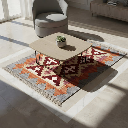 Kilim rug in the living room: geometric pattern in orange, cream, gray, and dark red