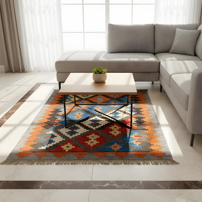 Kilim rug with a geometric pattern, gray background, orange and blue color blocks in the living area
