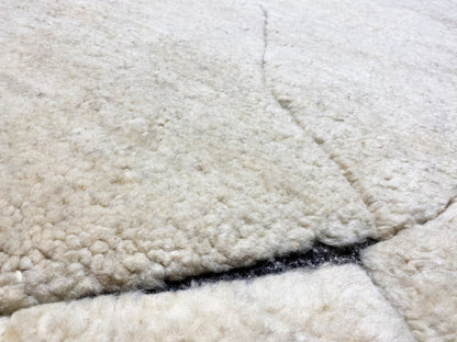 Close-up of the pile surface: cream-colored carpet with a blue border