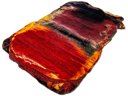 Designer rug in red with an orange-yellow gradient and dark areas, wavy edges