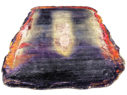 Designer rug with an abstract pattern in dark blue, purple, cream, and orange; bound edge.
