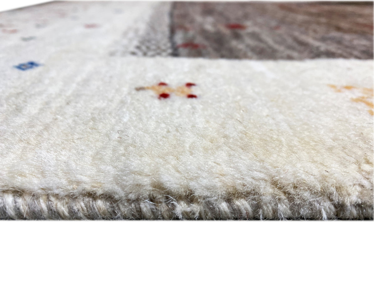 Close-up of the Gabbeh runner: beige pile with short fibers and a gray-dark patterned area