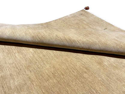 Gabbeh rug, light brown, side view, low pile with a white border and tassel at the top