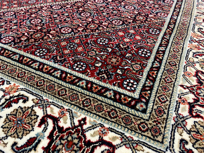 Bidjar carpet border detail: fine ornaments in dark red, cream, and blue with a border frieze