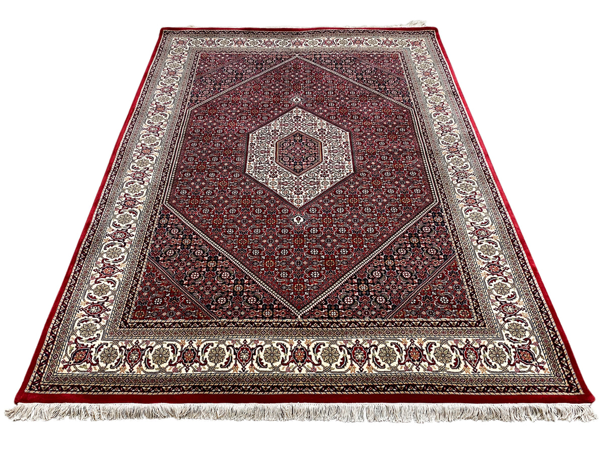 Red carpet with a square medallion, surrounding border, and fringe