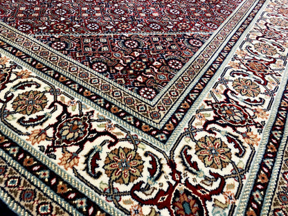 Rug with an ornamental pattern, dark base in shades of red, blue, and cream