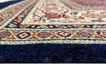Carpet corner with a delicate ornament and dark pile along the edge