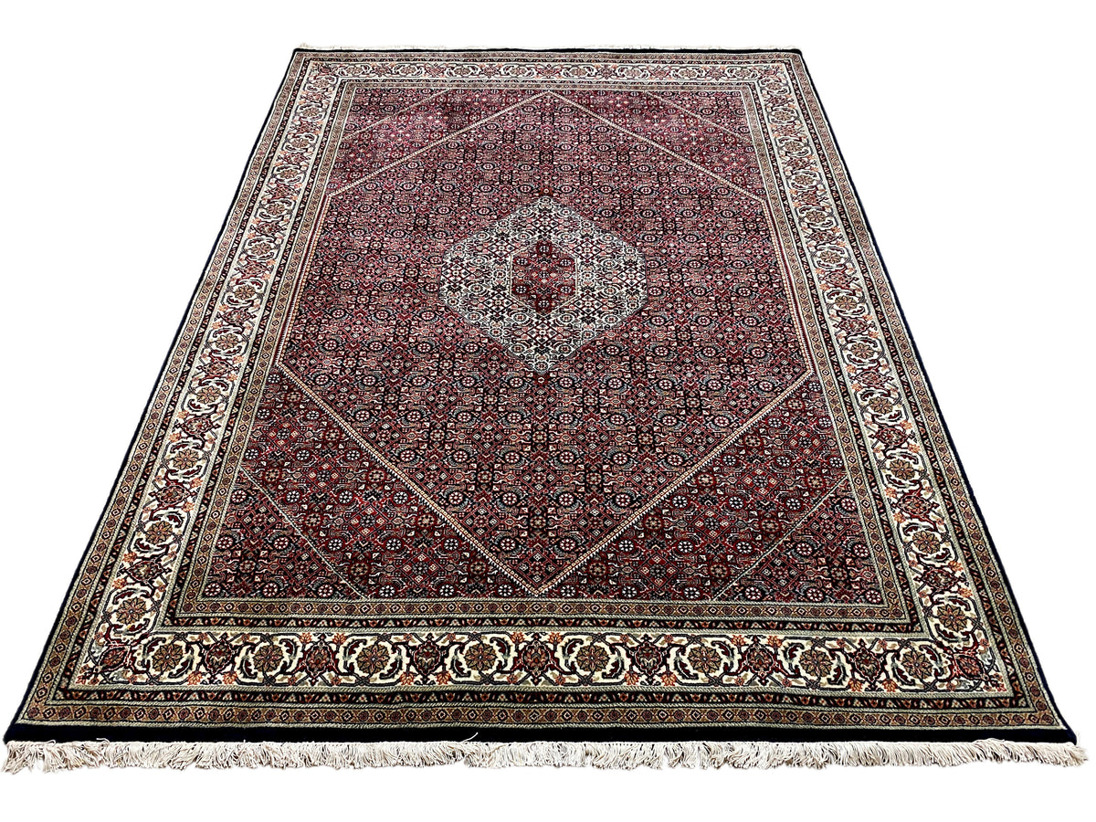 Rectangular Bidjar rug with a red ornamental pattern, central medallion, and fringes