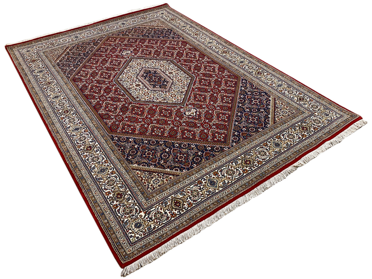 Square rug with a border, a red central medallion, and a blue-and-beige pattern