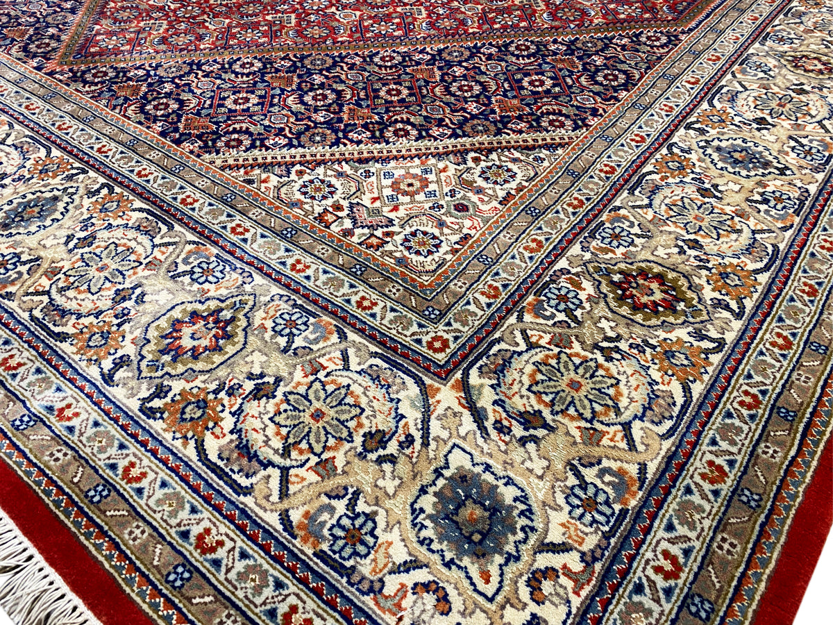Detailed view: blue center with floral motifs, surrounding ornaments, and red accents