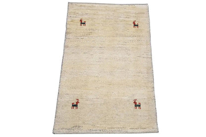 Gabbeh rug 96x60 cm: beige rug with a few red animal motifs